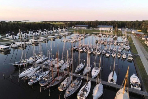 Vue aérienne de péniches et voiliers amarrés à la marina Houseboat à Peenemünde, près de bâtiments modernes.