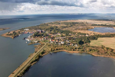 Aerial view from a houseboat in Peenemünde, overlooking the water, countryside, and local village.
