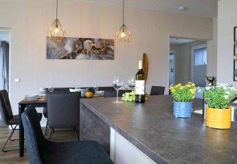 Comedor y cocina modernos en una casa flotante en Ribnitz-Damgarten, Alemania, con plantas y vino.
