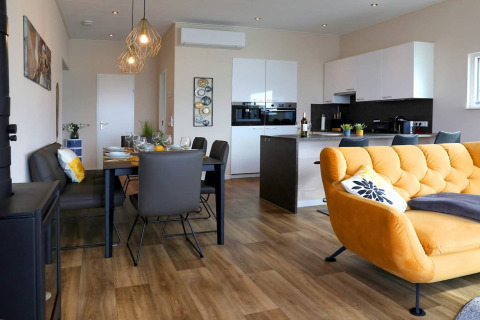 Moderne woon- en eetruimte op een woonboot in Ribnitz-Damgarten, Duitsland met gele sofa.