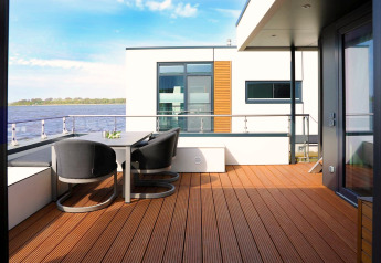 Moderne Hausboot-Terrasse mit Sitzbereich und Seeblick in Ribnitz-Damgarten, Deutschland.