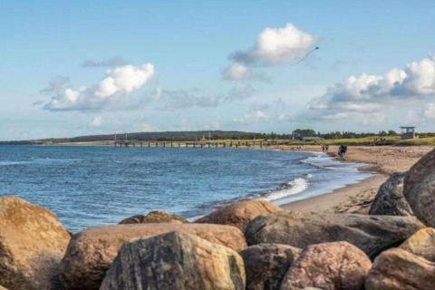 Billede af stranden og havet set fra Houseboat i Ribnitz-Damgarten med klipper i forgrunden og skyer.