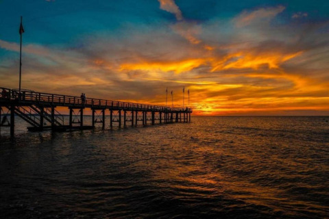 Stunning sunset captured from a houseboat in Ribnitz-Damgarten, featuring a pier stretching over calm water.