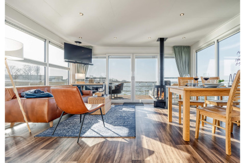 Bright, modern houseboat interior in Ribnitz-Damgarten with large windows offering a stunning water view.