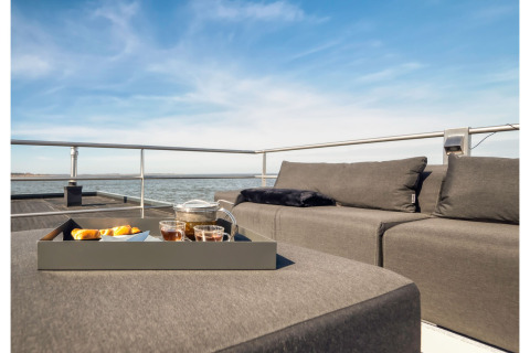 Modern lounge seating and tray with tea and snacks on a houseboat deck in Ribnitz-Damgarten, Germany.