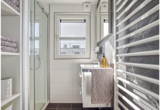 Modern bathroom on a houseboat in Ribnitz-Damgarten, Germany, featuring a shower, window, and heated towel rack.