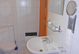 Bathroom on houseboat Floating House 1 in Germany featuring a sink, mirror, shelf, and toilet.