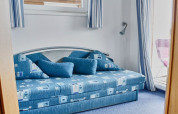 Blauwe slaapkamer met moderne sofa en grote kussens op een woonboot in Duitsland.