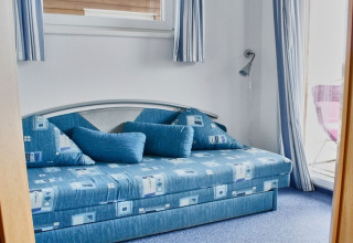 Camera da letto blu con divano moderno e grandi cuscini su una houseboat in Germania.