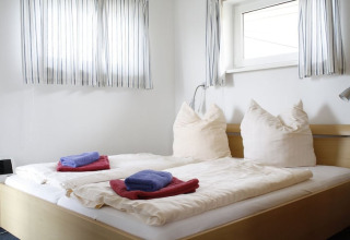 Camera da letto sulla houseboat 'Floating House 2 - Classic / 6 Persons' in Germania con letto matrimoniale e finestre.