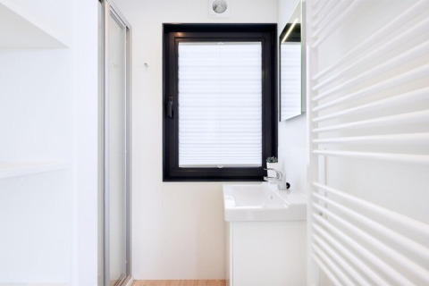 Bagno minimalista e luminoso della houseboat «Fjordblick» in Germania con finestra e lavabo.