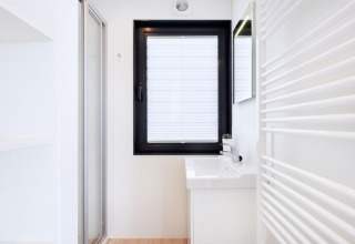 Salle de bain minimaliste et lumineuse de la houseboat « Fjordblick » en Allemagne, avec fenêtre et lavabo.