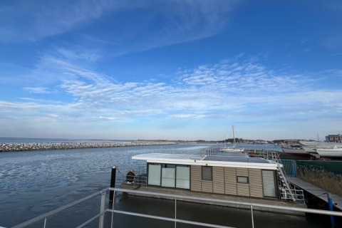 Photo de la péniche 'Fjordblick / 4 personnes' en Allemagne, amarrée dans un port paisible sous un ciel bleu.