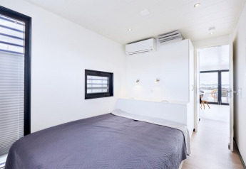 Chambre lumineuse avec lit double et déco moderne sur la péniche «Fjordblick / 6 Persons» en Allemagne.
