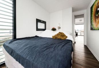 Soveværelse på husbåd 'Fjordblick / 6 Persons' i Tyskland med moderne indretning og store vinduer.