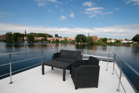 Vista dalla terrazza del houseboat Friedrich con sedie e tavolo e panorama sul fiume in Germania.
