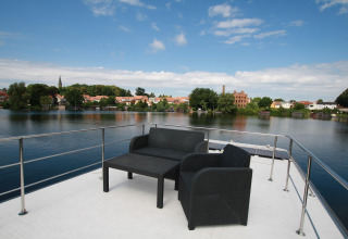Uitzicht op het dakterras van houseboat Friedrich met stoelen en zicht op de rivier in Duitsland.