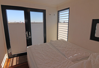 Bedroom in Houseboat Family & Friends LP2 with double bed, windows, and harbor view in Germany.