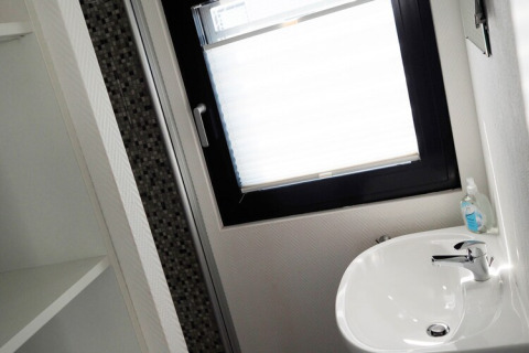 Moderne badkamer op woonboot Family & Friends LP2 in Duitsland met een wastafel en een groot raam.