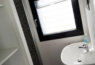 Moderne badkamer op woonboot Family & Friends LP2 in Duitsland met een wastafel en een groot raam.