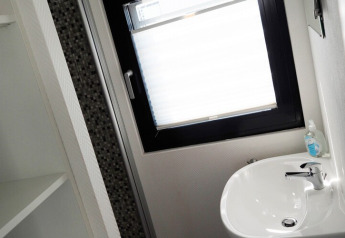 Moderne badkamer op woonboot Family & Friends LP2 in Duitsland met een wastafel en een groot raam.