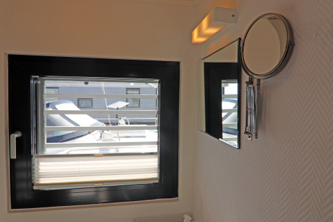 Badkamer op een woonboot met raam, spiegel en zicht op boot, Houseboat Family & Friends in Duitsland.