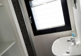 Lichte badkamer op woonboot met lavabo, zeepdispenser en groot raam, Houseboat in Duitsland.