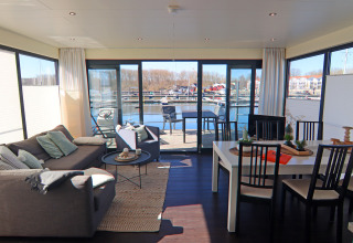 Woon- en eetruimte op woonboot Family & Friends LP 3 met uitzicht op de jachthaven in Duitsland.