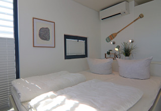 Camera luminosa e moderna su una houseboat con letto matrimoniale, aria condizionata e finestra.