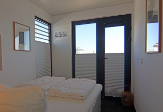 Chambre lumineuse sur houseboat 'Family & Friends LP 3 / 4 Persons' en Allemagne, lit, fenêtres et déco murale.