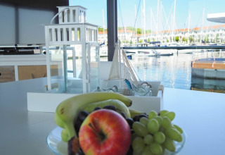Frutero y linterna sobre una mesa con vistas al puerto desde el Houseboat Family & Friends en Alemania.