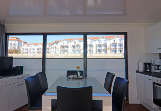 Dining area and kitchenette aboard Houseboat 'Family & Friends LP 1' in Germany, with view of apartments.