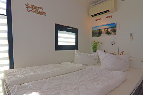 Bedroom on houseboat 'Family & Friends LP 1' in Germany, featuring double bed, window, and wall art decor.