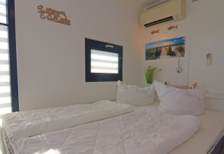 Bedroom on houseboat 'Family & Friends LP 1' in Germany, featuring double bed, window, and wall art decor.