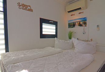 Dormitorio en la casa flotante 'Family & Friends LP 1' en Alemania con cama doble, ventana y decoración.