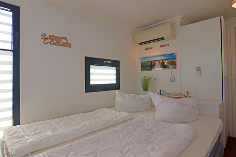 Bright bedroom on a houseboat with double bed, air conditioning, nautical decor and window.
