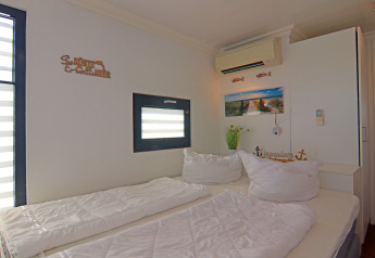 Dormitorio luminoso en una casa flotante con cama doble, aire acondicionado y decoración náutica.