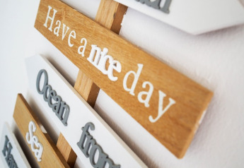 Close-up of a wooden sign on a houseboat in Germany, reading 'Have a nice day' in white letters.