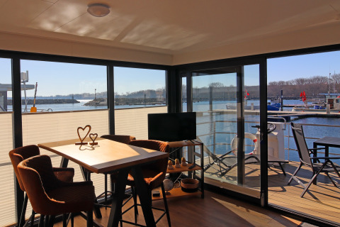 Living area view from Houseboat 'Family & Friends mit Hund LP 10' in Germany, overlooking a marina.