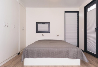 Modern bedroom on houseboat 'Family & Friends mit Hund LP 10', neutral design with a gray bedcover.