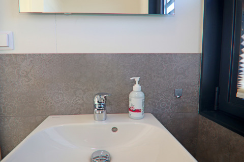 Modern washbasin with soap dispenser and chrome faucet in a houseboat bathroom in Germany.