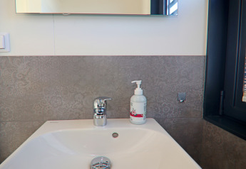 Lavabo moderne avec distributeur de savon et robinet chromé dans une salle de bain de péniche en Allemagne.