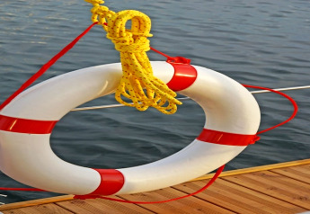 Reddingsboei met geel touw aan de reling van houseboat Floating 44 bij het water in Duitsland.