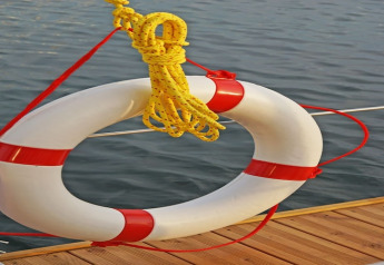 Reddingsboei met geel touw aan de reling van houseboat Floating 44 bij het water in Duitsland.