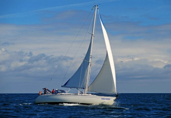 Zeilboot op zee onder een blauwe lucht met wolken, gezien vanaf Floating 44 - Boat 2 in Duitsland.