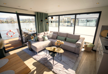 Gezellige woonkamer op een woonboot in Höxter met groot raam, ruim salon en zicht op het water.