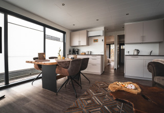 Espace salon et cuisine moderne dans une péniche à Höxter, avec grandes fenêtres et ambiance chaleureuse.