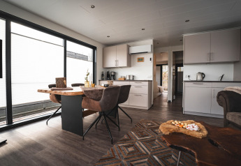 Espace salon et cuisine moderne dans une péniche à Höxter, avec grandes fenêtres et ambiance chaleureuse.
