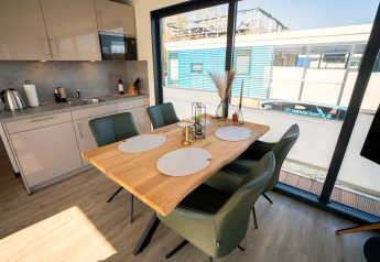Moderne eet- en keukenruimte op een woonboot in Höxter met vier stoelen en grote ramen.