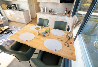Comedor y cocina modernos en una casa flotante en Höxter, Alemania, con vistas al agua desde grandes ventanas.